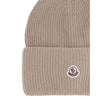 Beige Wool BeanieThe beanie hat by Moncler is a versatile wool accessory with a classic cut, perfect for both city days and outdoor adventures. Designed to provide warmth and comfort, this knitted hat is made from high-quality carded wool. The medium-weig