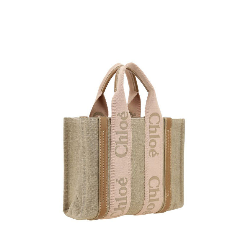 Beige Linen HandbagChloé’s Woody Handbag is an elegant and practical accessory made of linen and detailed with contrasting leather. The concealed button top closure maintains a clean design, while the double flat handles and extension on the leather side