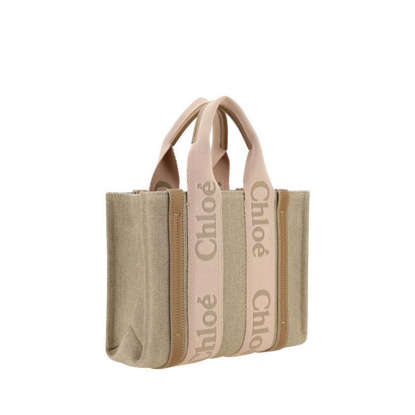 Beige Linen HandbagChloé’s Woody Handbag is an elegant and practical accessory made of linen and detailed with contrasting leather. The concealed button top closure maintains a clean design, while the double flat handles and extension on the leather side