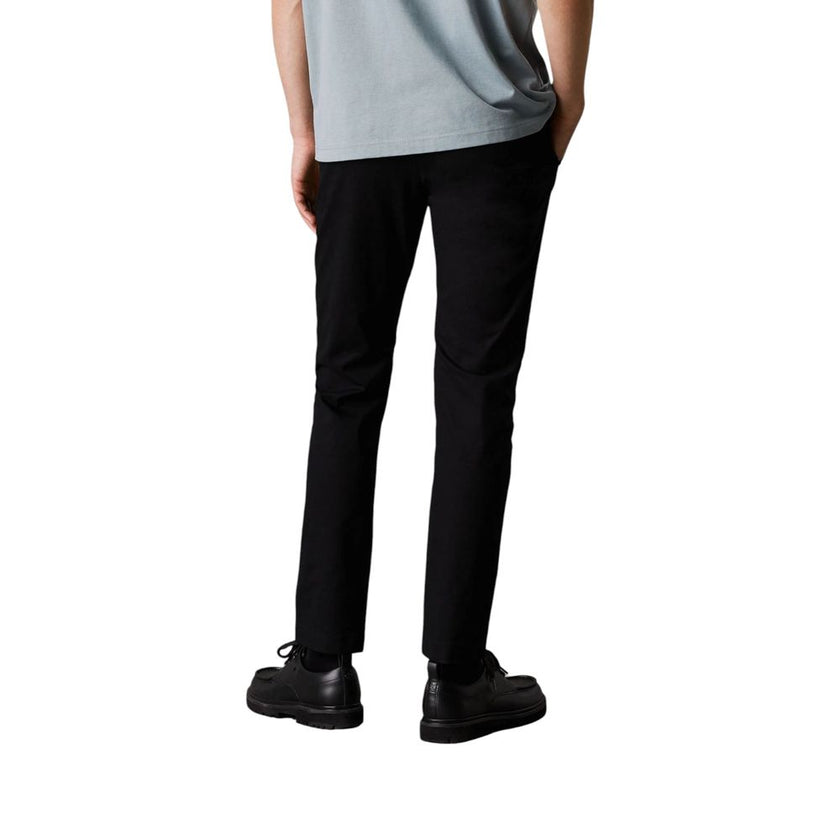 Black Recycled Cotton PantDiscover the TAPERED CHINO J30J326847 pants by Calvin Klein Jeans, a perfect balance of style and comfort. Made with a composition of 97% recycled cotton and 3% elastane/lycra, these pants offer a regular fit and a soft feel agai