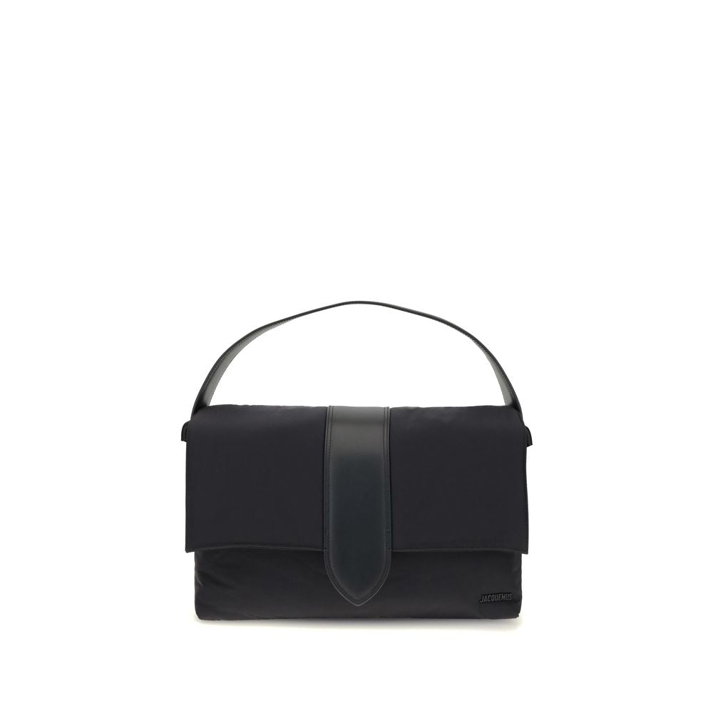 Black Nylon Shoulder BagThe Bambino Shoulder Bag by Jacquemus reinterprets the messenger style with a practical, contemporary design. Made of padded nylon, it features a leather handle and magnetic flap with tab, combined with a zipper closure for added s