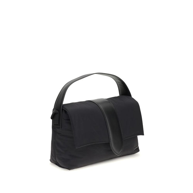 Black Nylon Shoulder BagThe Bambino Shoulder Bag by Jacquemus reinterprets the messenger style with a practical, contemporary design. Made of padded nylon, it features a leather handle and magnetic flap with tab, combined with a zipper closure for added s