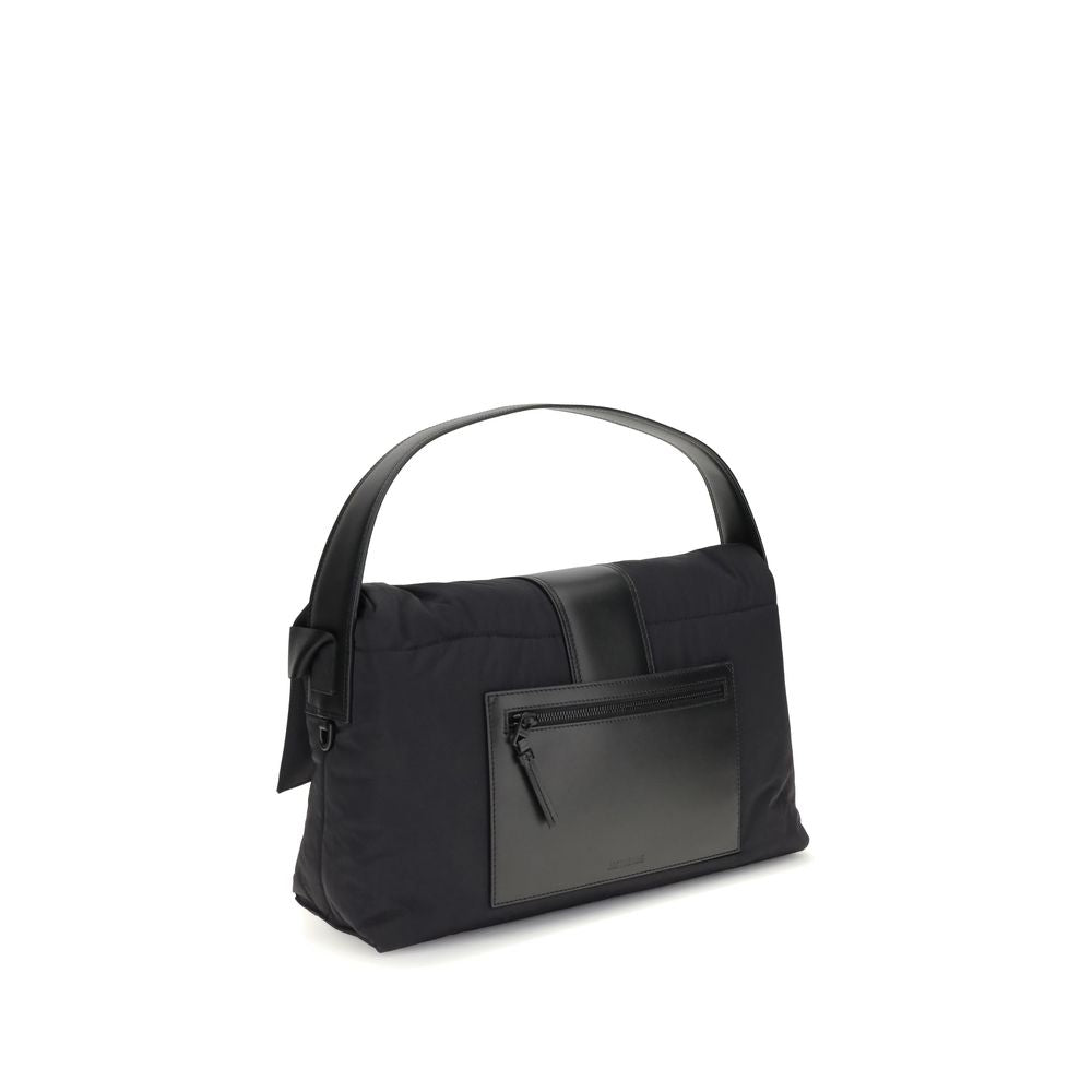 Black Nylon Shoulder BagThe Bambino Shoulder Bag by Jacquemus reinterprets the messenger style with a practical, contemporary design. Made of padded nylon, it features a leather handle and magnetic flap with tab, combined with a zipper closure for added s