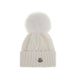 Cashmere blend Hat with pom-ponMoncler’s cashmere blend Hat combines softness and style in a stylish and functional accessory. Made from a Cable and Aran knit, it features a logo patch on the front that underscores its identity. Completing the design is t