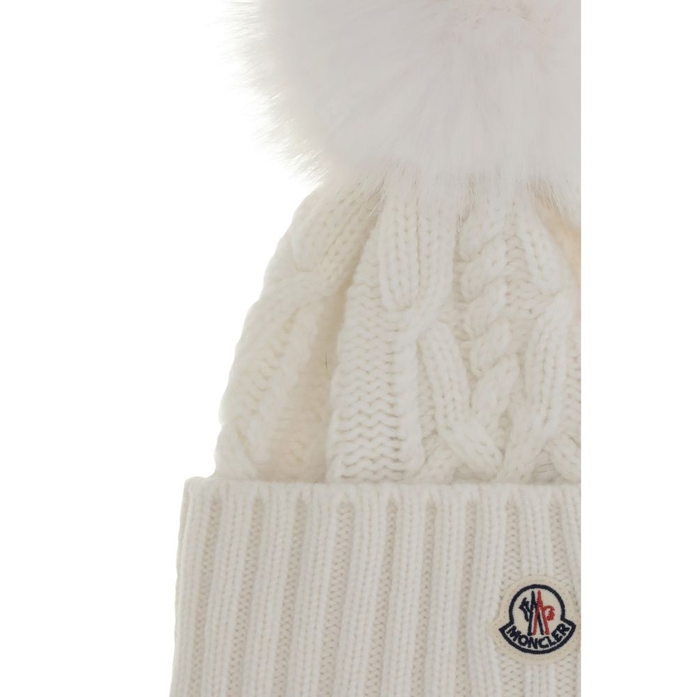 Cashmere blend Hat with pom-ponMoncler’s cashmere blend Hat combines softness and style in a stylish and functional accessory. Made from a Cable and Aran knit, it features a logo patch on the front that underscores its identity. Completing the design is t