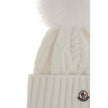 Cashmere blend Hat with pom-ponMoncler’s cashmere blend Hat combines softness and style in a stylish and functional accessory. Made from a Cable and Aran knit, it features a logo patch on the front that underscores its identity. Completing the design is t