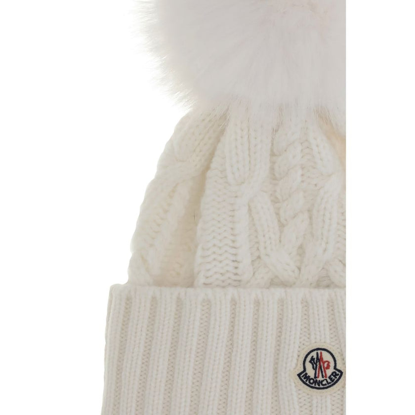 Cashmere blend Hat with pom-ponMoncler’s cashmere blend Hat combines softness and style in a stylish and functional accessory. Made from a Cable and Aran knit, it features a logo patch on the front that underscores its identity. Completing the design is t