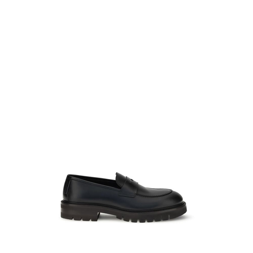 Black Rubber Slip-On LoafersFerragamo’s Penny Loafers reinterpret a classic with a contemporary twist. Featuring a slightly rounded toe and a brushed calfskin upper, they offer the perfect balance of elegance and comfort. Iconic details, such as the conto