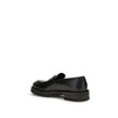 Black Rubber Slip-On LoafersFerragamo’s Penny Loafers reinterpret a classic with a contemporary twist. Featuring a slightly rounded toe and a brushed calfskin upper, they offer the perfect balance of elegance and comfort. Iconic details, such as the conto