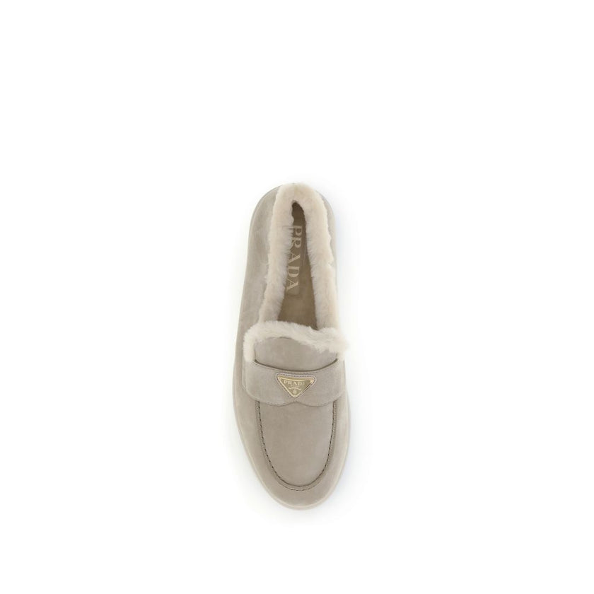 Beige Rubber Slip-On LoafersPrada’s suede Loafers combine comfort and sophistication in a contemporary design. Featuring a round toe and a soft fur lining, they are embellished with the triangular logo plaque on the front, the house’s iconic detail. Seaso