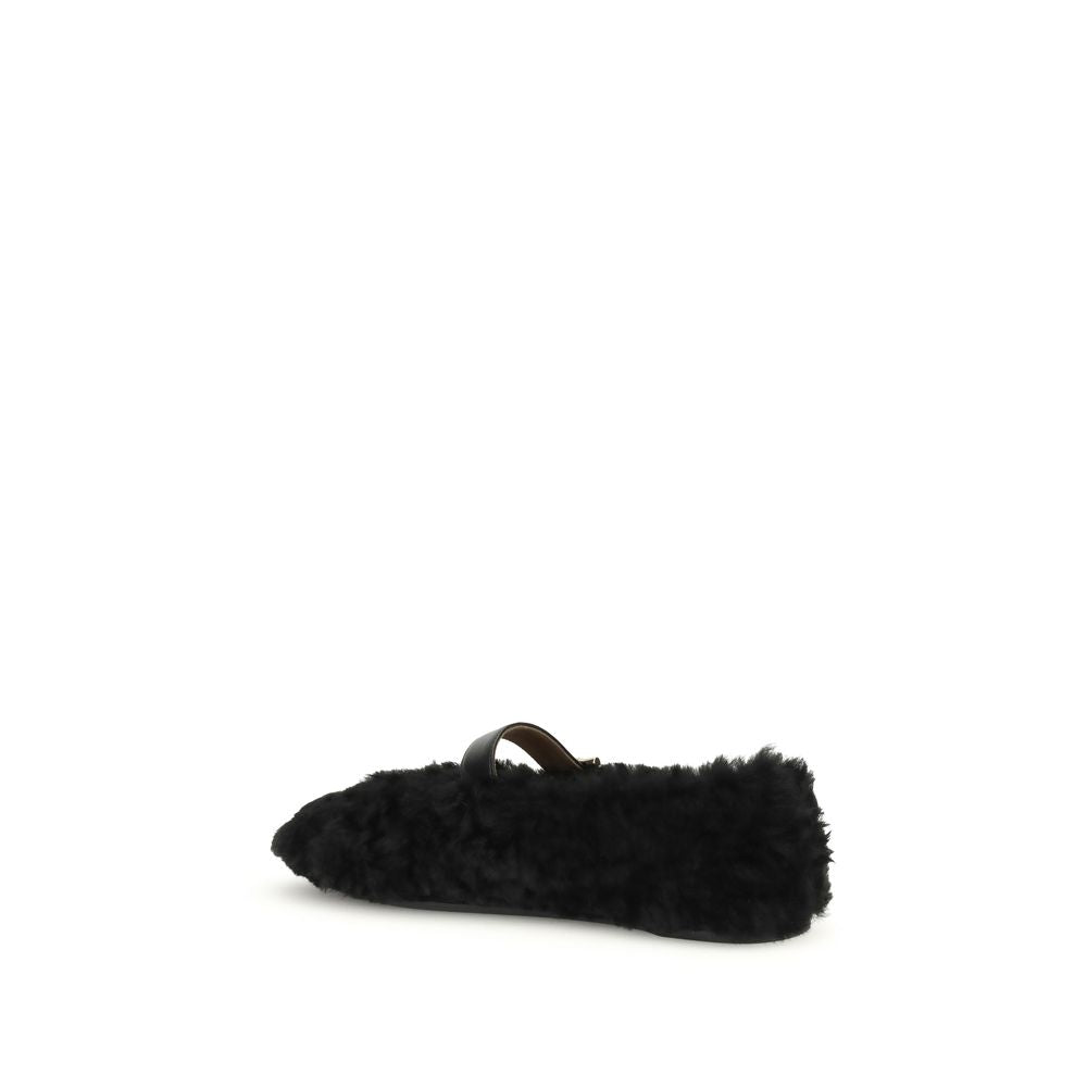 Black Fur Ballet FlatsFerragamo’s Gancini-embellished Ballerinas by Ferragamo reinterprets a classic with a playful, contemporary twist. Featuring a contoured neckline and soft silhouette, it is distinguished by a curly shearling lining, ideal for the col
