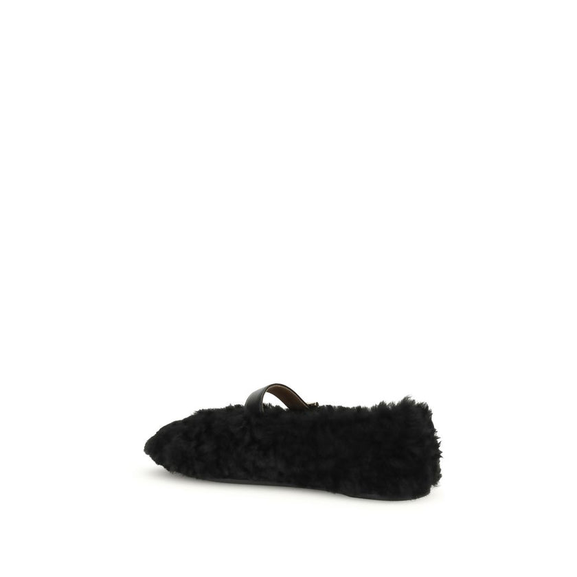 Black Fur Ballet FlatsFerragamo’s Gancini-embellished Ballerinas by Ferragamo reinterprets a classic with a playful, contemporary twist. Featuring a contoured neckline and soft silhouette, it is distinguished by a curly shearling lining, ideal for the col