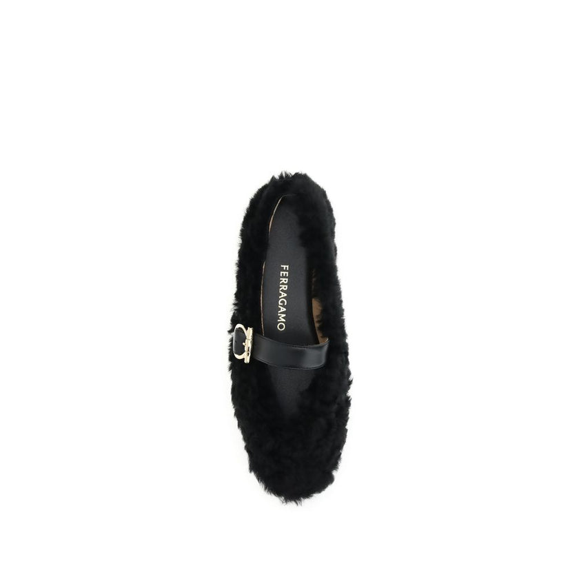 Black Fur Ballet FlatsFerragamo’s Gancini-embellished Ballerinas by Ferragamo reinterprets a classic with a playful, contemporary twist. Featuring a contoured neckline and soft silhouette, it is distinguished by a curly shearling lining, ideal for the col
