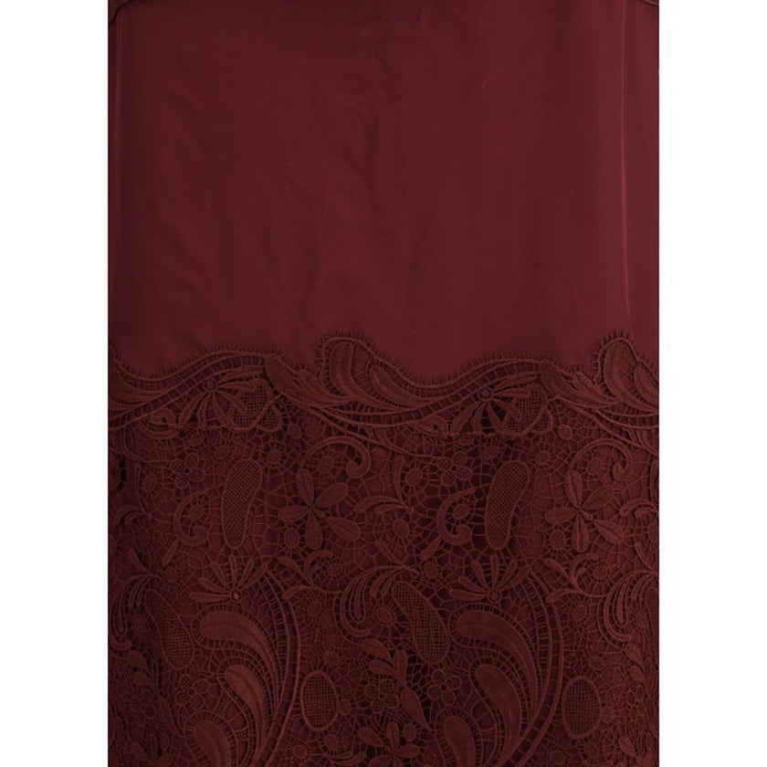 Bordeaux Silk Cocktail DressFerragamo’s Draped Dress is a refined contemporary reinterpretation of 1920s elegance. Made of a blend of silk chiffon, satin, and embroidery, it is distinguished by wide bands that wrap the silhouette harmoniously. The draped