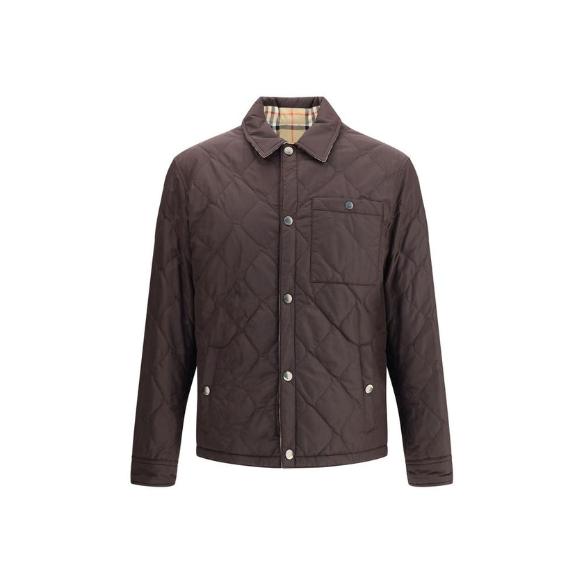 Brown Polyamide CoatBurberry’s Reversible quilted Jacket is a smock made of lightweight, water-resistant nylon with one side in solid color and the other in Burberry Check cotton twill. It features a regular fit and snap button closure with embossed logo.