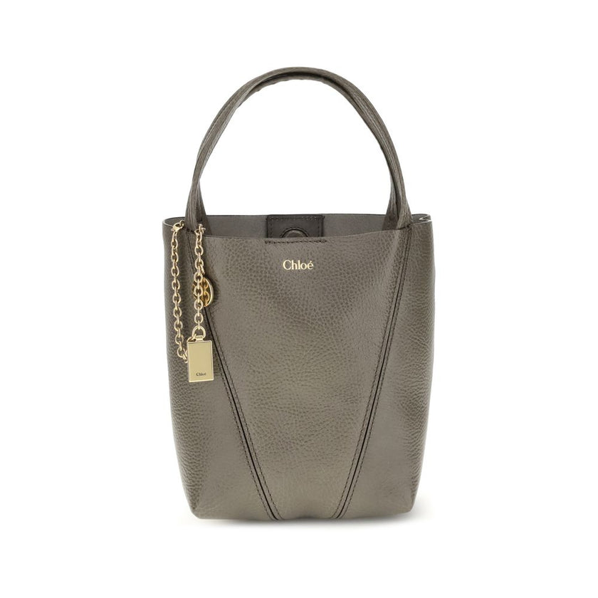 Gray Calf Leather Bos Taurus Shoulder BagThe Spin Shoulder Bag by Chloé, crafted by shiny grained leather, features an elegant design with two flat top handles and an adjustable shoulder strap. The closure is secured by a magnetic button, while the detail