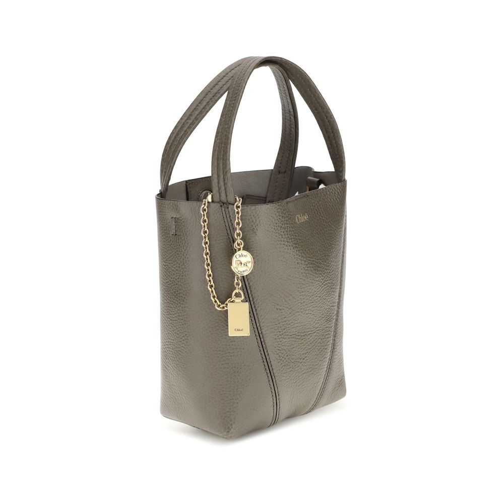 Gray Calf Leather Bos Taurus Shoulder BagThe Spin Shoulder Bag by Chloé, crafted by shiny grained leather, features an elegant design with two flat top handles and an adjustable shoulder strap. The closure is secured by a magnetic button, while the detail
