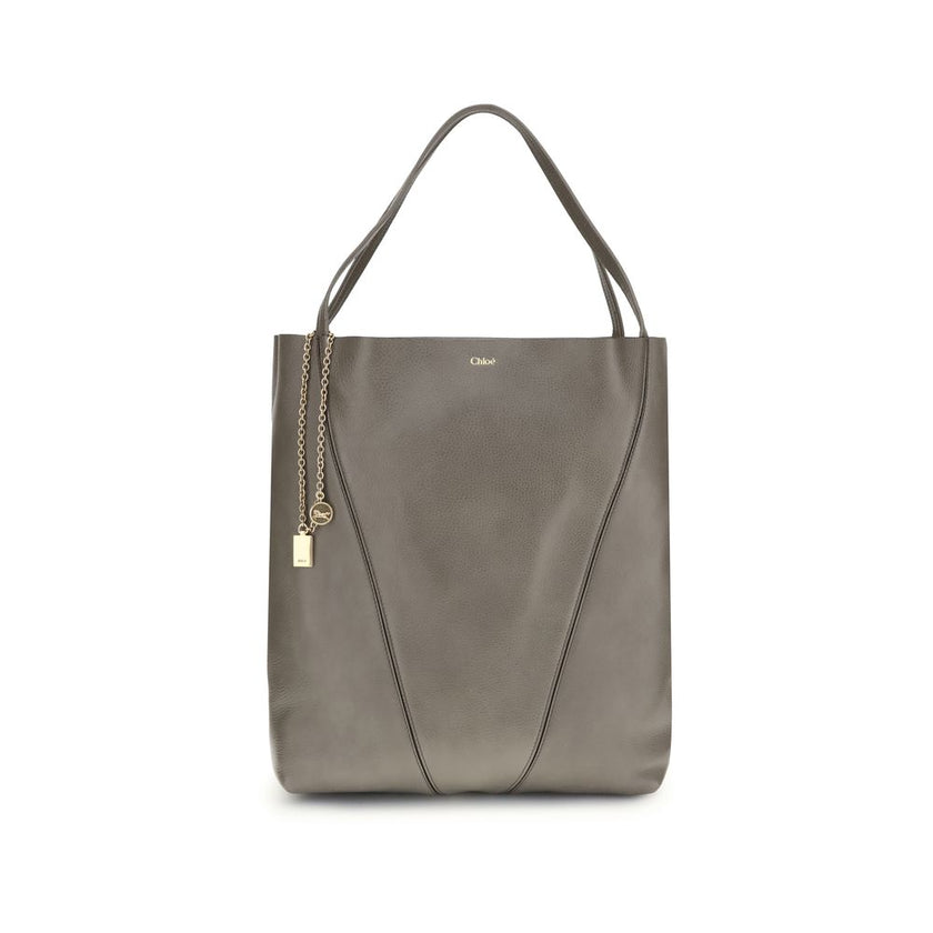 Gray Calf Leather Bos Taurus Shoulder BagChloé’s Spin Large Tote Bag is crafted in glossy garnet cowhide and features a minimalist silhouette with graphic and elegant lines. A distinctive detail is the hanging chain with Chloé medals and the Horse emblem,