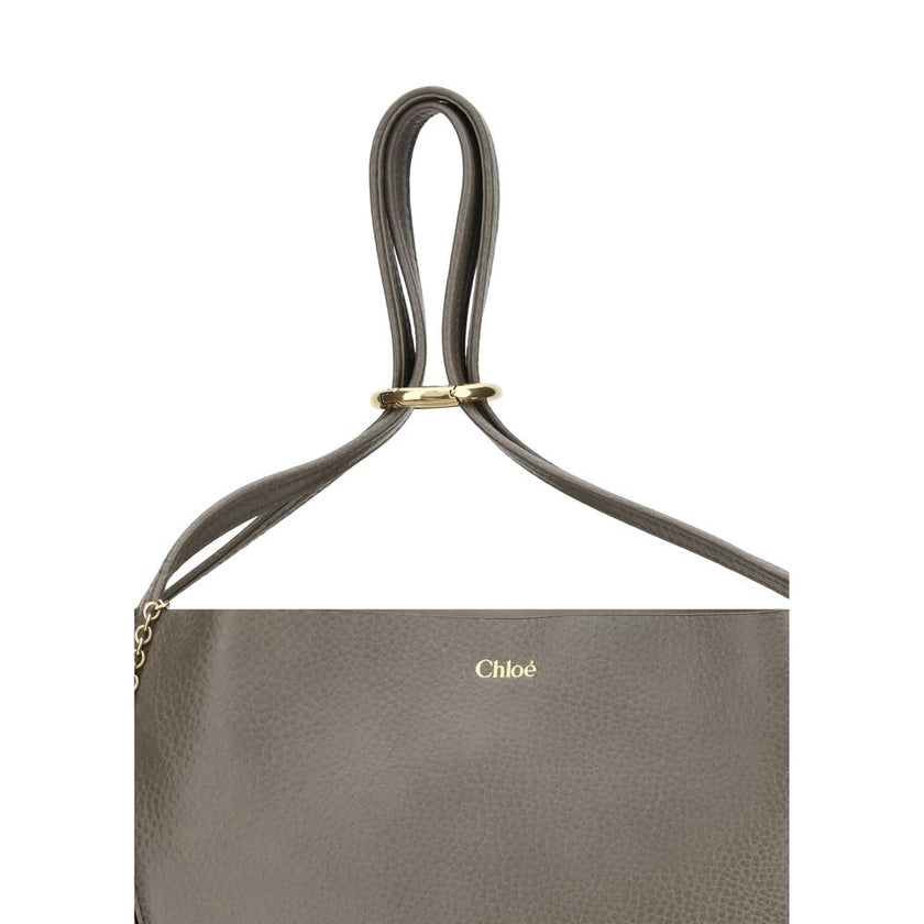 Gray Calf Leather Bos Taurus Shoulder BagChloé’s Spin Large Tote Bag is crafted in glossy garnet cowhide and features a minimalist silhouette with graphic and elegant lines. A distinctive detail is the hanging chain with Chloé medals and the Horse emblem,