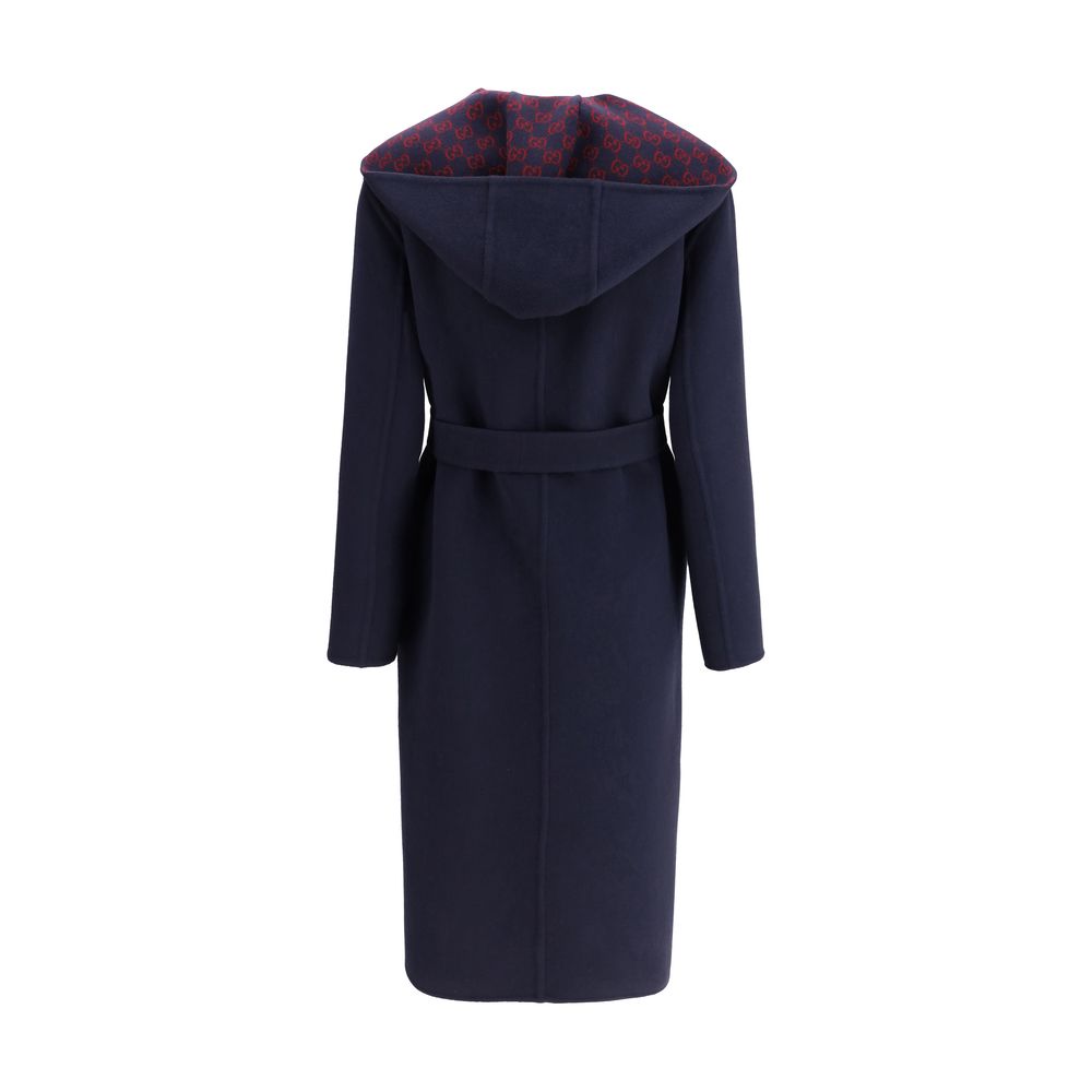 Blue Wool CoatGucci’s wool Coat is a long style with a timelessly elegant design. Featuring a hood and matching removable and knotted sash, it combines practicality and style. The two side welt pockets add functionality to the garment, while the iconic Gu