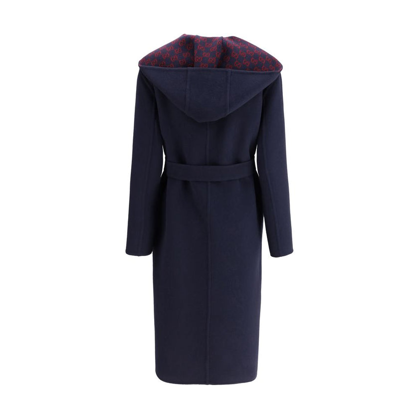 Blue Wool CoatGucci’s wool Coat is a long style with a timelessly elegant design. Featuring a hood and matching removable and knotted sash, it combines practicality and style. The two side welt pockets add functionality to the garment, while the iconic Gu