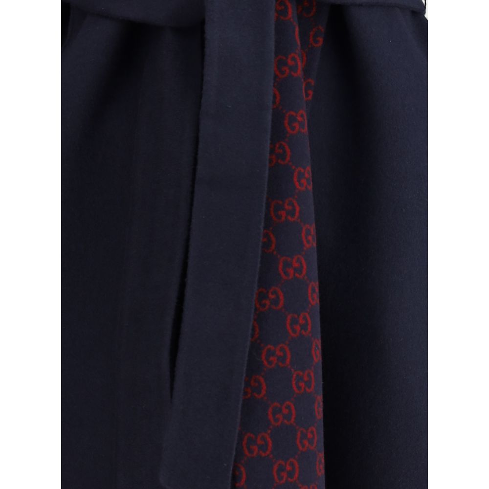 Blue Wool CoatGucci’s wool Coat is a long style with a timelessly elegant design. Featuring a hood and matching removable and knotted sash, it combines practicality and style. The two side welt pockets add functionality to the garment, while the iconic Gu