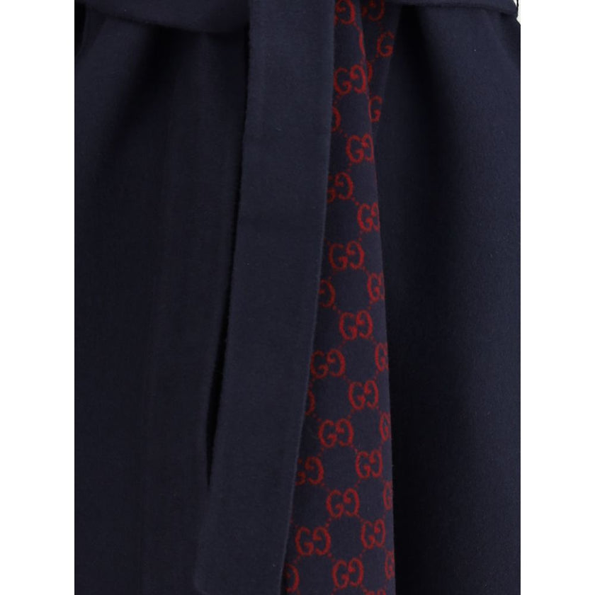 Blue Wool CoatGucci’s wool Coat is a long style with a timelessly elegant design. Featuring a hood and matching removable and knotted sash, it combines practicality and style. The two side welt pockets add functionality to the garment, while the iconic Gu