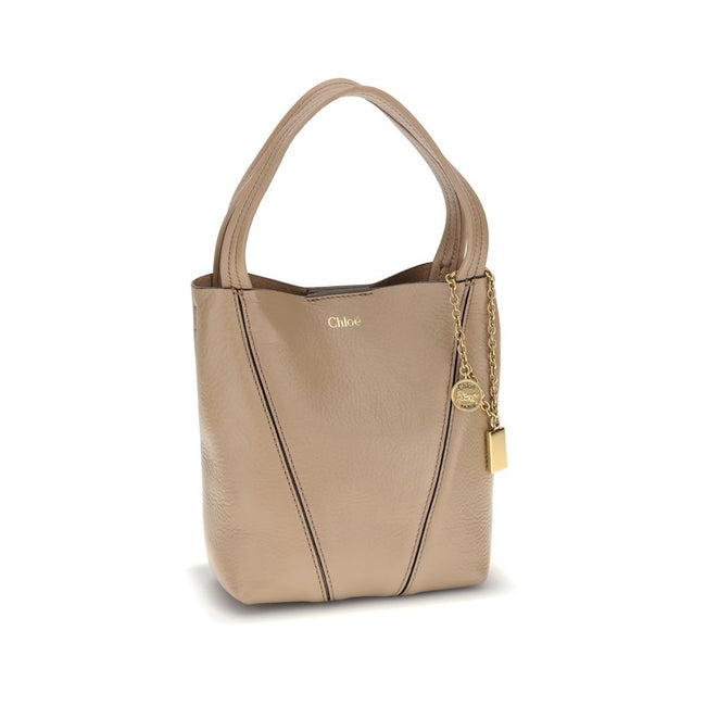Beige Calf Leather Bos Taurus Shoulder BagThe Spin Shoulder Bag by Chloé, crafted by shiny grained leather, features an elegant design with two flat top handles and an adjustable shoulder strap. The closure is secured by a magnetic button, while the detai