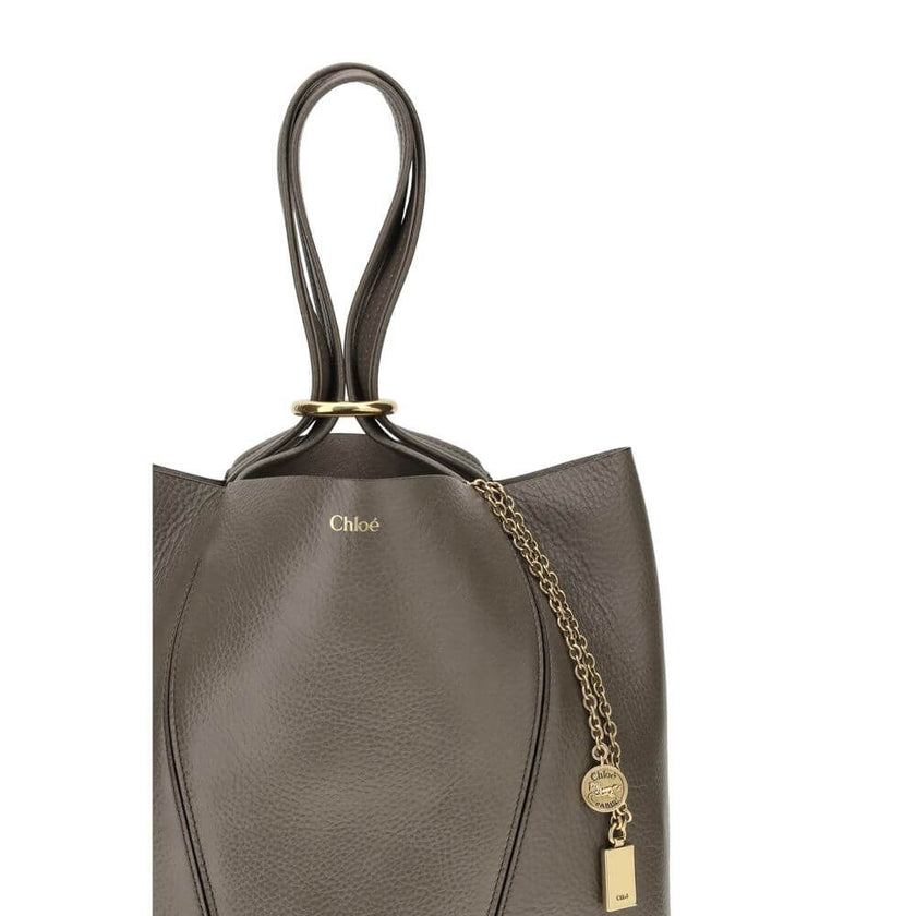 Spin Shoulder BagLeather Spin Shoulder Bag by Chloé is a refined and modern accessory featuring a sleek grained leather design. The two flat top handles offer a comfortable and practical grip, while the brand’s iconic monogram, press-stamped on the front,