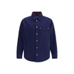 Blue Denim ShirtGucci’s reversible Shirt combines dark blue délavé denim on one side and soft red and blue brushed GG flannel on the other. Featuring a pointed collar, chest pocket, side pockets and long sleeves, it has a front closure with Gucci metal bu
