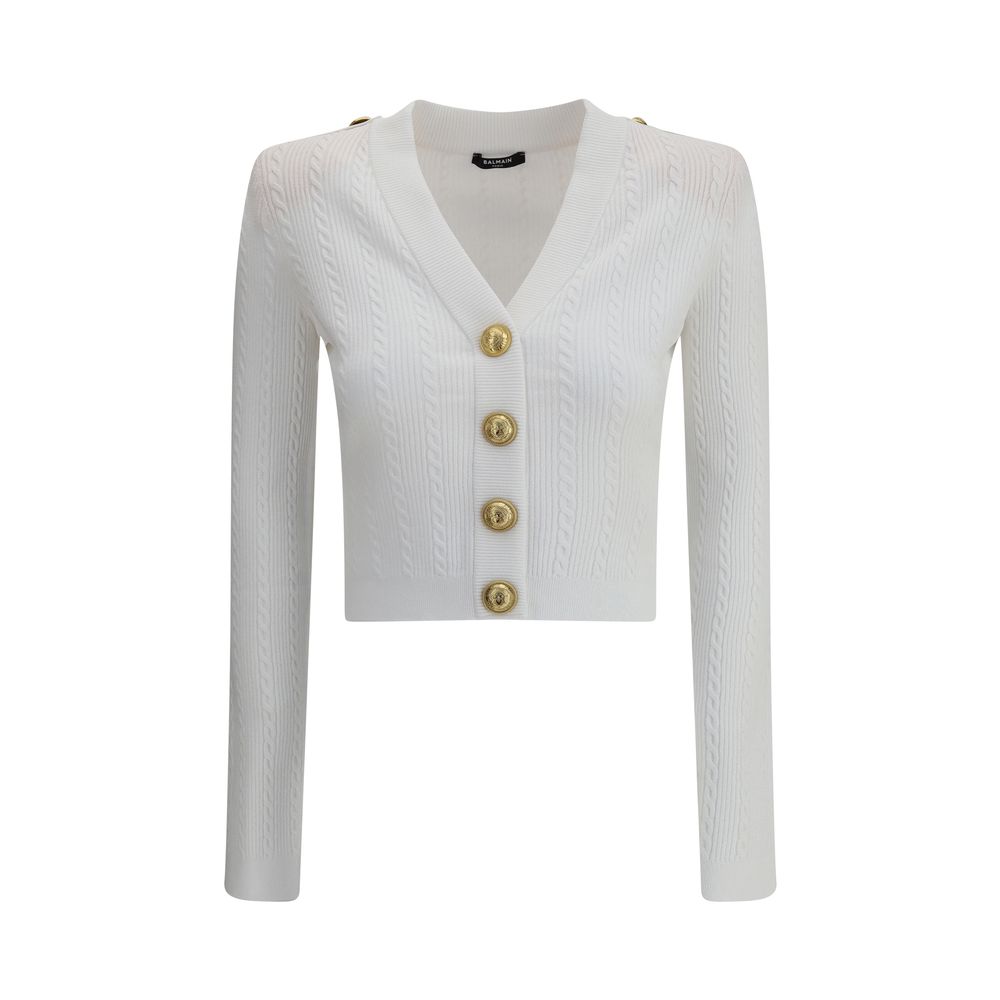 Ribbed and braided CardiganBalmain’s Ribbed and braided Cardigan combines elegance and structure in a distinctive design. Featuring a V-neckline, it features structured shoulders with decorative tabs and buttons, recalling the military aesthetic dear to t