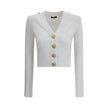 Ribbed and braided CardiganBalmain’s Ribbed and braided Cardigan combines elegance and structure in a distinctive design. Featuring a V-neckline, it features structured shoulders with decorative tabs and buttons, recalling the military aesthetic dear to t