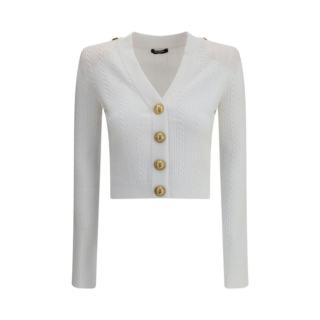 Ribbed and braided CardiganBalmain’s Ribbed and braided Cardigan combines elegance and structure in a distinctive design. Featuring a V-neckline, it features structured shoulders with decorative tabs and buttons, recalling the military aesthetic dear to t