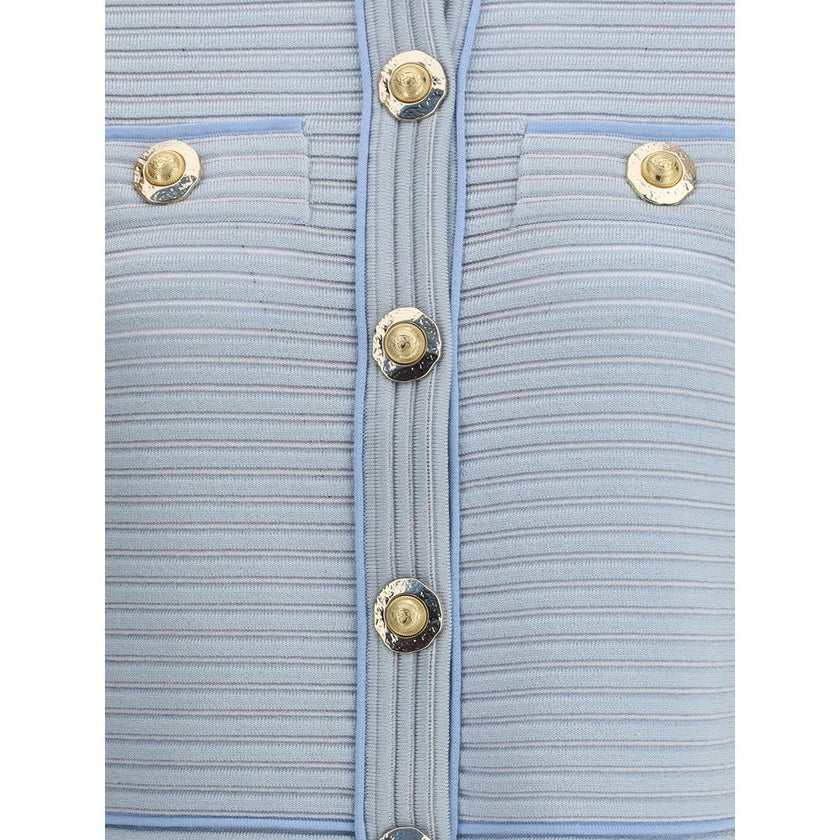 Light Blue Viscose CardiganBalmain’s Cardigan is a garment with a structured design and refined elegance. The front closure with five snap buttons is paired with two trompe-l’œil pockets enriched with decorative metal 