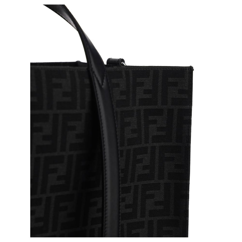 Black Polyester Shoulder BagThe Tote Handbag by Fendi features a double rigid handle at the top, a removable and adjustable leather shoulder strap, and an internal welt pocket with a zipper closure. The exterior is adorned with the brand’s iconic FF print