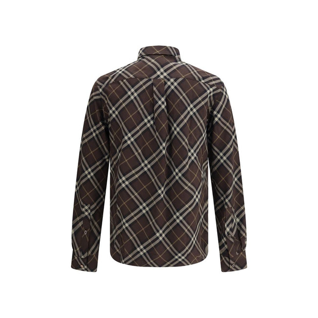 Brown Cotton Pattern ShirtBurberry’s Check cotton flannel Shirt is a timeless classic that combines tradition and contemporary style. Made of soft cotton flannel woven with the famous Burberry Check pattern, it features long sleeves, a button-down collar
