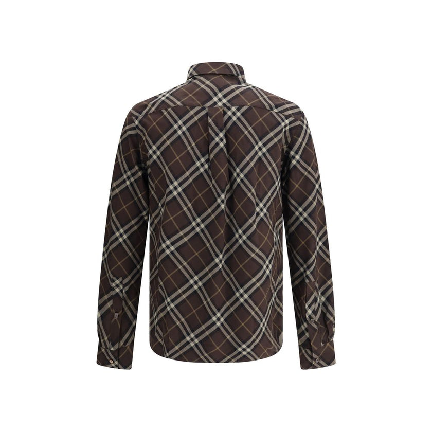 Brown Cotton Pattern ShirtBurberry’s Check cotton flannel Shirt is a timeless classic that combines tradition and contemporary style. Made of soft cotton flannel woven with the famous Burberry Check pattern, it features long sleeves, a button-down collar