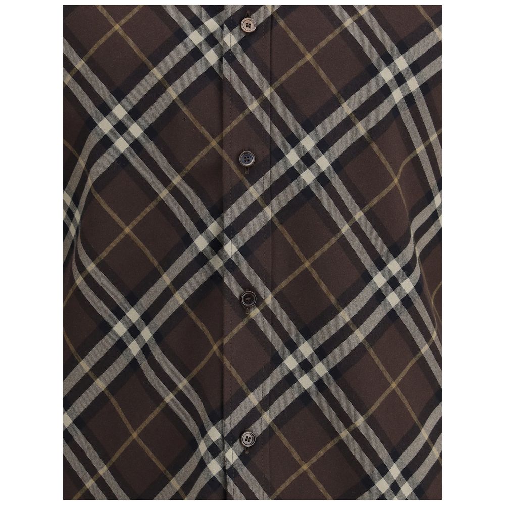 Brown Cotton Pattern ShirtBurberry’s Check cotton flannel Shirt is a timeless classic that combines tradition and contemporary style. Made of soft cotton flannel woven with the famous Burberry Check pattern, it features long sleeves, a button-down collar