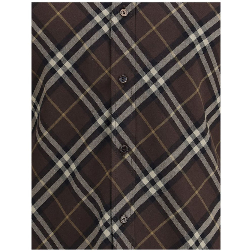 Brown Cotton Pattern ShirtBurberry’s Check cotton flannel Shirt is a timeless classic that combines tradition and contemporary style. Made of soft cotton flannel woven with the famous Burberry Check pattern, it features long sleeves, a button-down collar