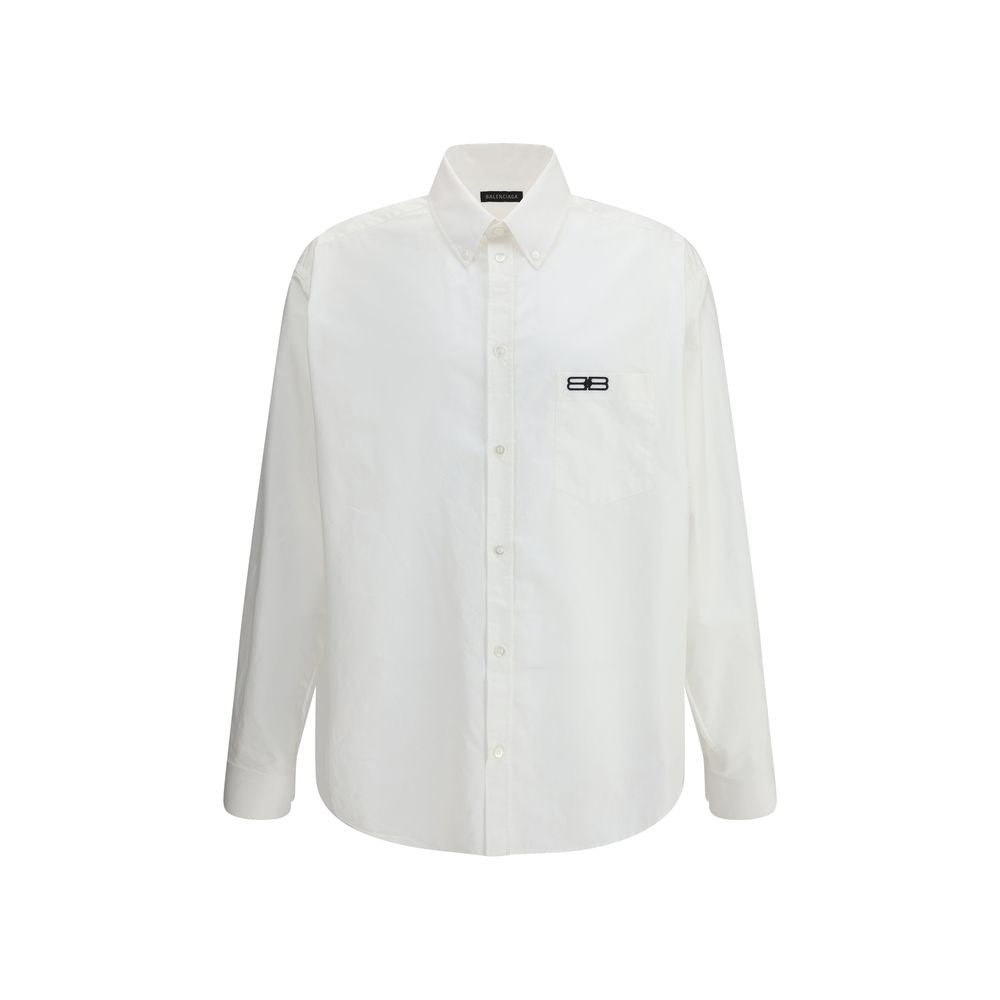 White Cotton Dress ShirtBalenciaga’s oversized cotton Shirt features a contemporary and striking design. It features a front button closure, a classic collar and an asymmetrical hem that adds dynamism to the silhouette. A small patch pocket on the front,