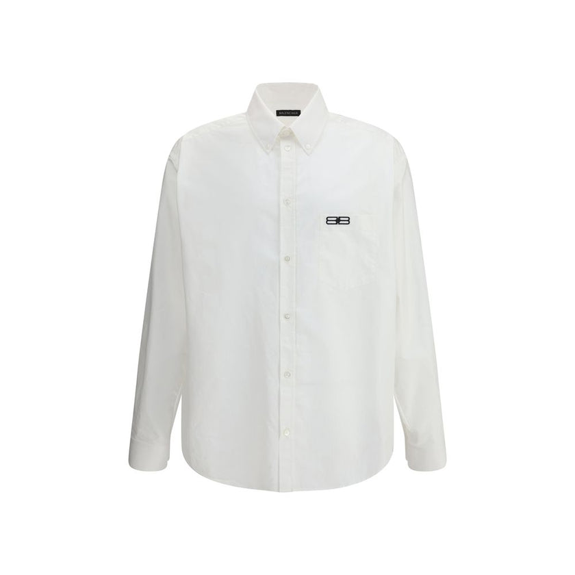 White Cotton Dress ShirtBalenciaga’s oversized cotton Shirt features a contemporary and striking design. It features a front button closure, a classic collar and an asymmetrical hem that adds dynamism to the silhouette. A small patch pocket on the front,