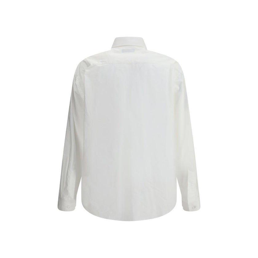 White Cotton Dress ShirtBalenciaga’s oversized cotton Shirt features a contemporary and striking design. It features a front button closure, a classic collar and an asymmetrical hem that adds dynamism to the silhouette. A small patch pocket on the front,