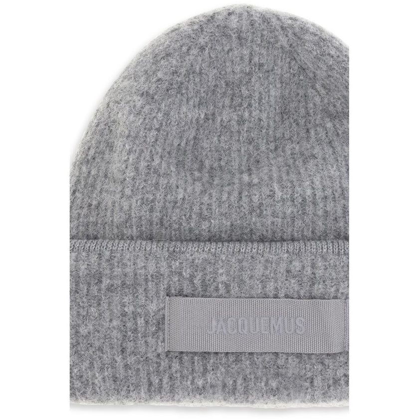 Gros Grain Ribbed BeanieThe Gros Grain Ribbed Beanie by Jacquemus combines style and functionality. The adjustable fit ensures comfort, while the contrasting folded brim and tone-on-tone gros-grain logo embroidered on the front complete the design with a
