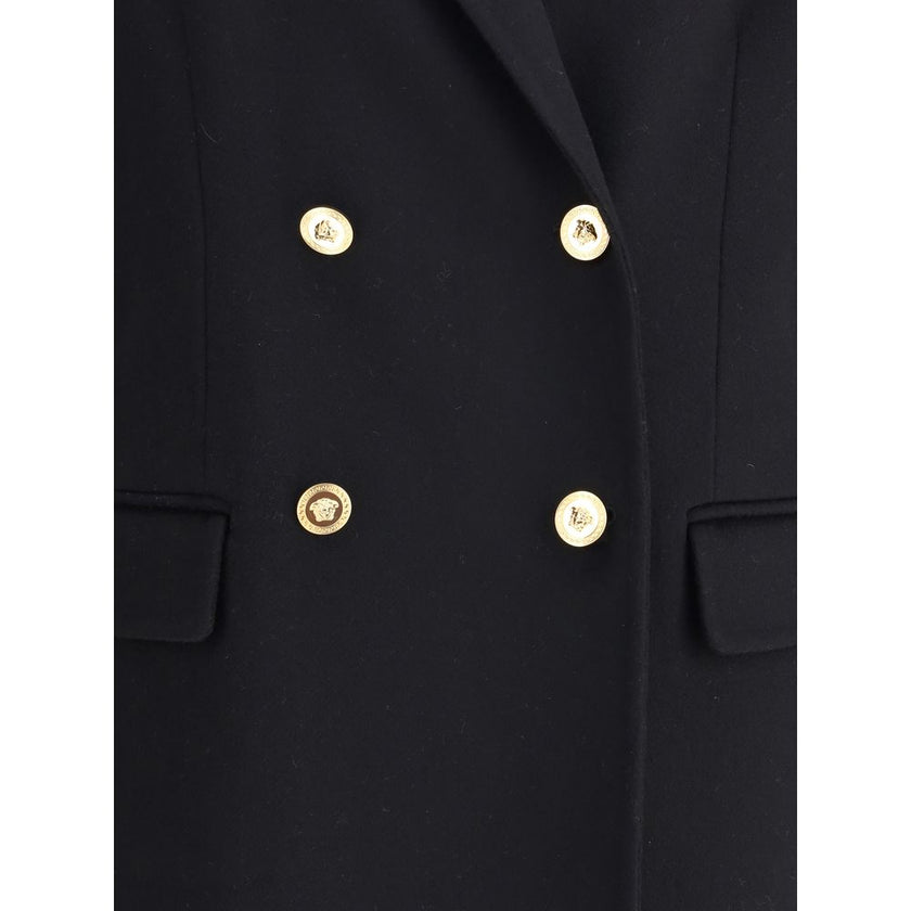 Black Cashmere CoatThe Double-breasted Coat in wool and cashmere blend by Versace combines sartorial elegance with iconic details. The notched lapel, long sleeves, and front patch pockets enhance the coat’s classic lines, while the Safety Pin accessory an