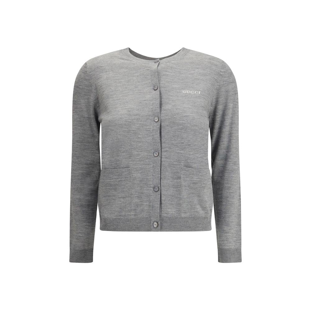 Gray Cashmere CardiganGucci’s cashmere Cardigan is a timeless garment, the epitome of elegance and comfort. Featuring a ribbed crew neck, hem and cuffs, it has a front button closure and two small patch pockets on the front. The iconic stitched signature