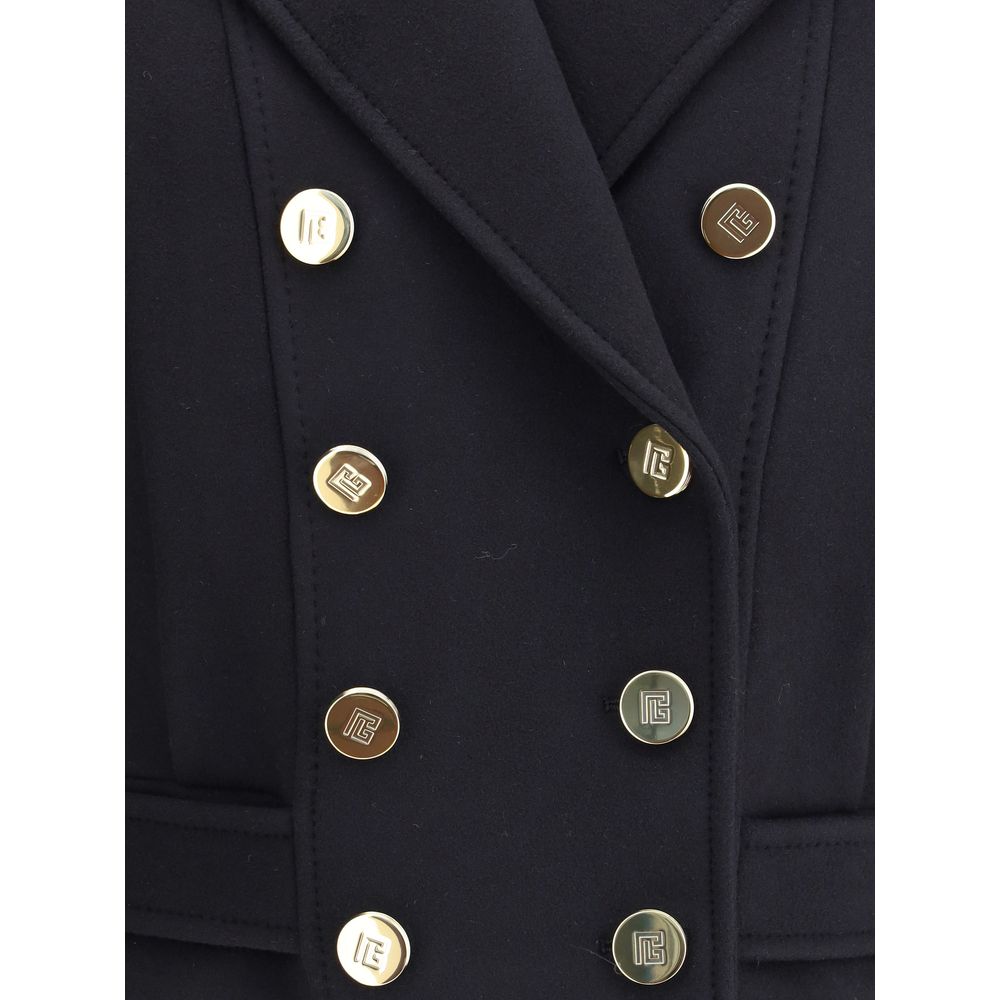 Black Wool CoatThe double-breasted coat by Balmain combines sophistication with contemporary modernity. Crafted from fine wool, its streamlined silhouette with broad shoulders and wide lapels flatters the figure, while the engraved gold buttons, decorativ