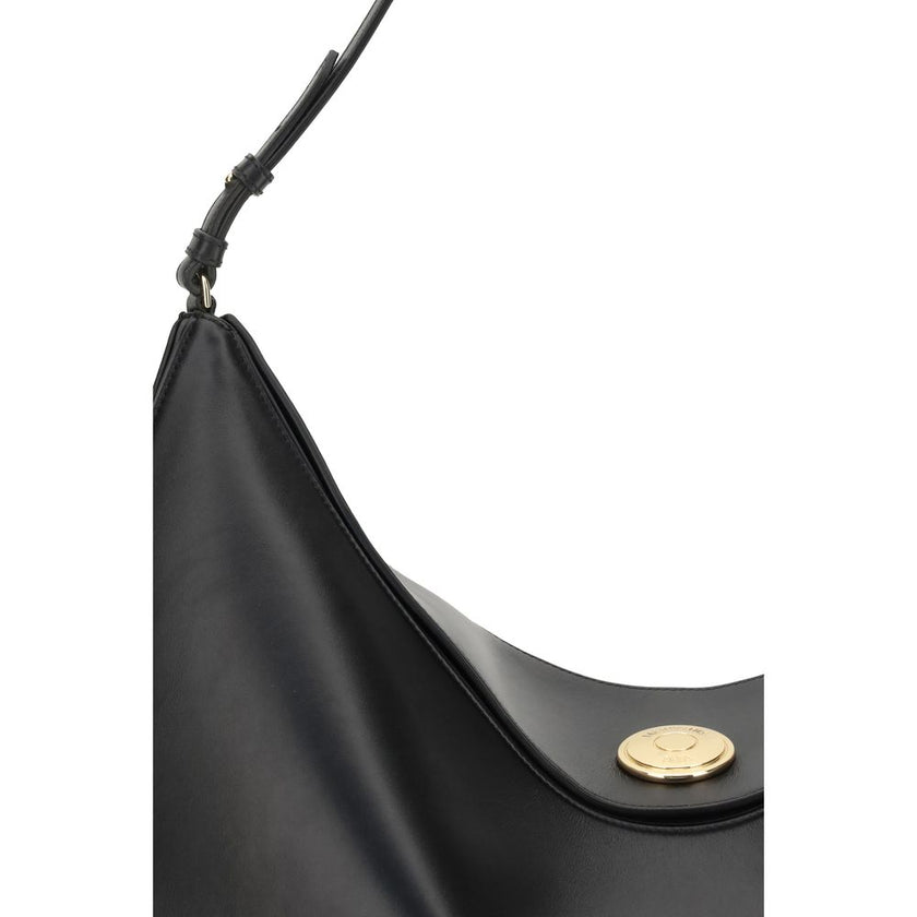 Black Calf Leather Bos Taurus Shoulder BagThe Ovalo Bag by Jacquemus is an elegant large hobo bag crafted from smooth leather, featuring a slim shoulder strap for easy carrying. The flap with a large engraved snap button ensures secure closure, while the
