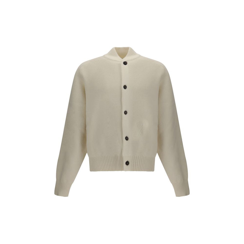 White Fleece Wool CardiganThe Virgin Wool Cardigan by Jacquemus combines elegance and comfort, featuring front buttons that emphasize its refined silhouette. The long sleeves and ribbed trims add a touch of classic style, while the embroidered detail on t