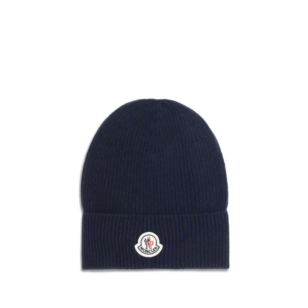 Blue Wool BeanieThe Moncler wool and cashmere hat is crafted from a soft blend of blue virgin wool and cashmere, using Italian craftsmanship. One size fits all, it guarantees warmth, comfort, and a touch of elegance. Season: AW25 Composition: 70% Wool 30%