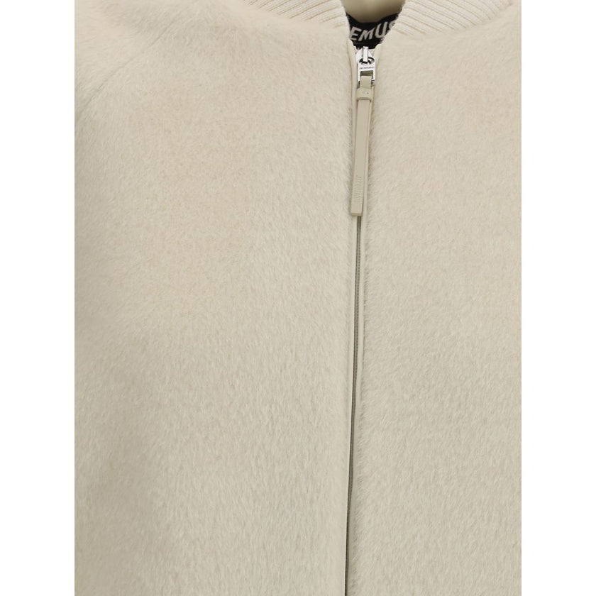 White Wool BomberThe Jacquemus Le Blouson Pilu jacket in white alpaca wool features a round neckline, front zip closure, and raglan long sleeves. Finished with ribbed wool edges, it combines comfort and sophisticated design in a contemporary piece Season: